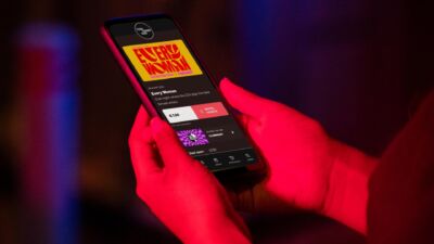 Iemand bekijkt in het donker een website in dark mode op een mobiele telefoon