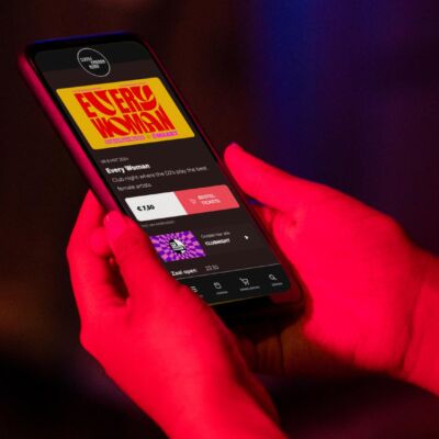 Iemand bekijkt in het donker een website in dark mode op een mobiele telefoon